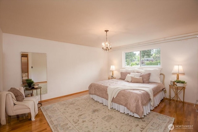 bedroom featuring wood finished floors and a chandelier