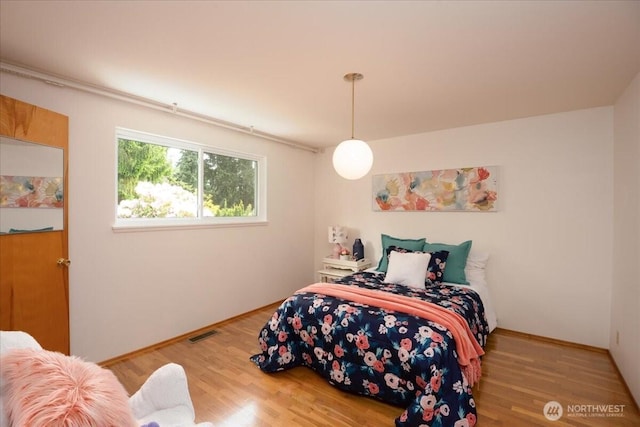 bedroom with wood finished floors and baseboards