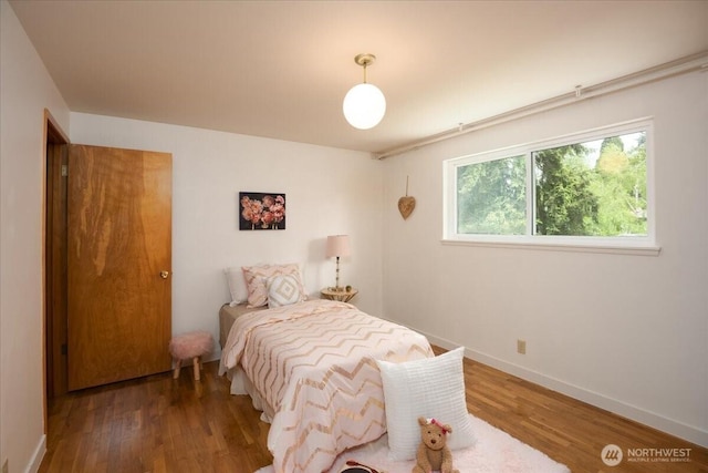 bedroom with wood finished floors and baseboards