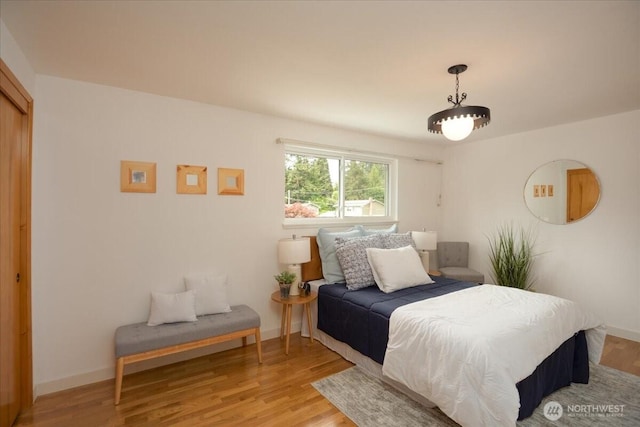 bedroom with light wood-style flooring and baseboards