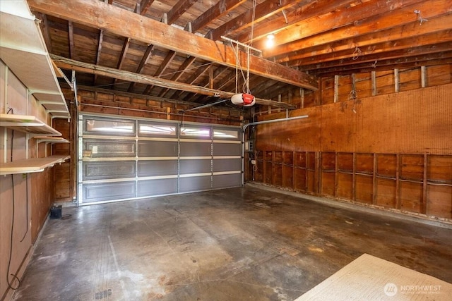 garage with a garage door opener and wooden walls