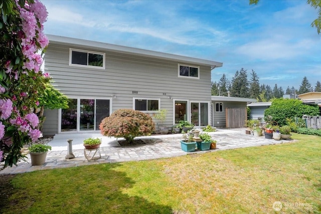 rear view of property featuring a patio area and a yard