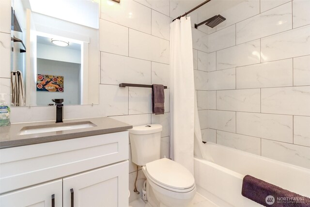 bathroom featuring vanity, shower / tub combo, toilet, and tile walls
