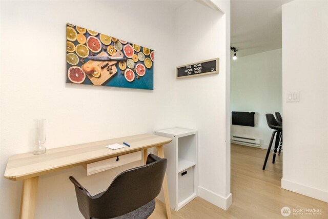 office area featuring baseboards, wood finished floors, and baseboard heating