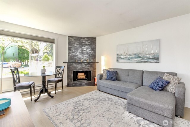 living area with a tiled fireplace and wood finished floors