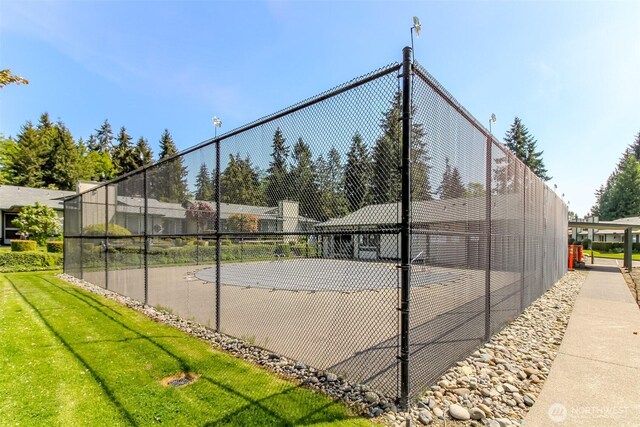 view of tennis court featuring fence