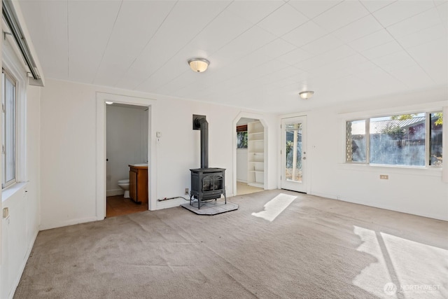 406 S Chestnut St, Ellensburg, WA 98926 - unfurnished living room featuring arched walkways, carpet floors, and a wood stove
