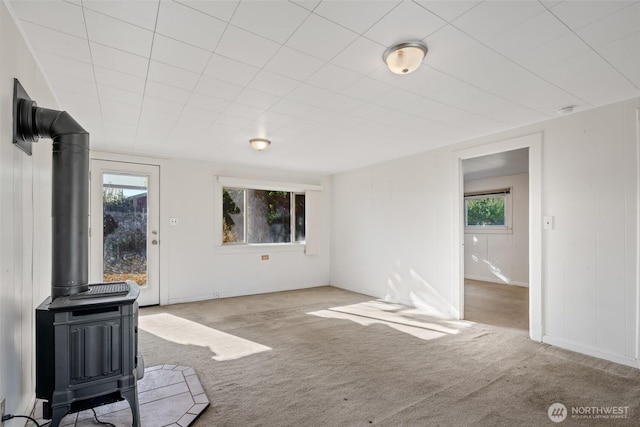 406 S Chestnut St, Ellensburg, WA 98926 - unfurnished living room with carpet flooring, a wood stove, and a healthy amount of sunlight