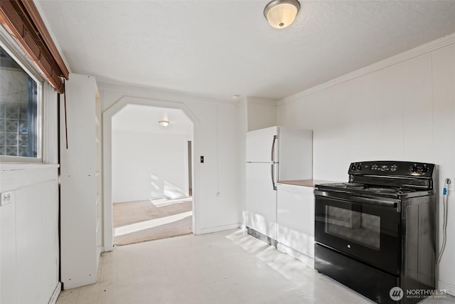 406 S Chestnut St, Ellensburg, WA 98926 - kitchen with black / electric stove, light floors, ornamental molding, arched walkways, and freestanding refrigerator
