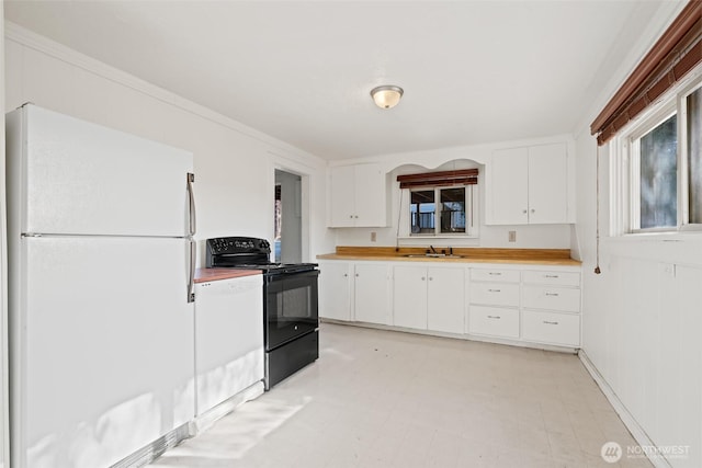 406 S Chestnut St, Ellensburg, WA 98926 - kitchen with white cabinets, a sink, freestanding refrigerator, black range with electric stovetop, and light floors