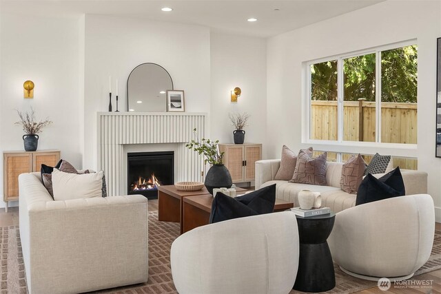living area featuring recessed lighting and a lit fireplace