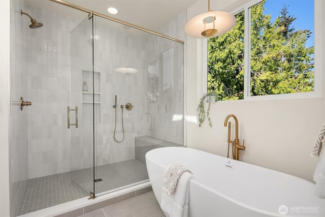 full bath featuring a soaking tub, a shower stall, and tile patterned flooring