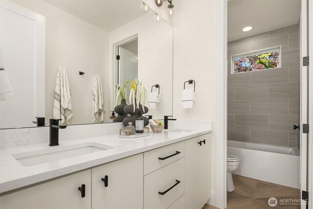 bathroom featuring toilet and double vanity