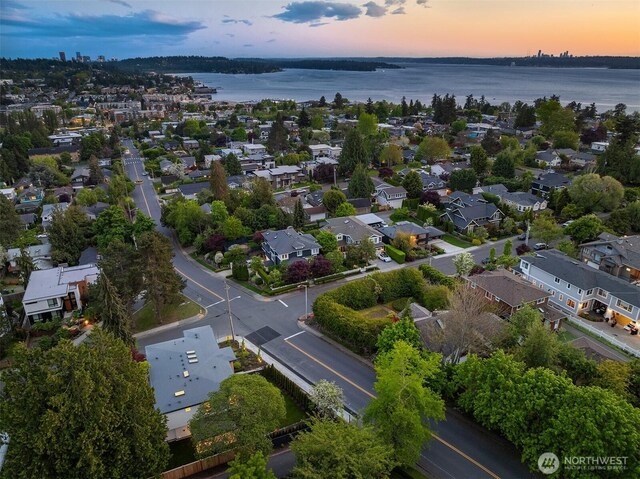 aerial view at dusk of a water view and a residential view