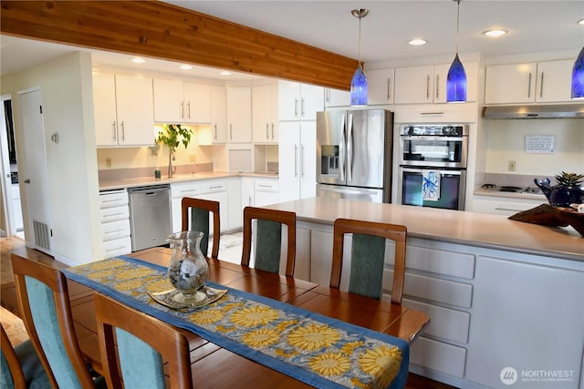 2426 Eastpoint Dr, Langley, WA 98260 - kitchen with appliances with stainless steel finishes, under cabinet range hood, white cabinets, hanging light fixtures, and recessed lighting