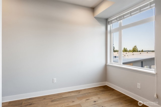 unfurnished room with baseboards and wood finished floors