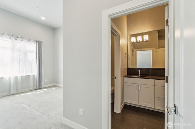 hallway with a sink and baseboards