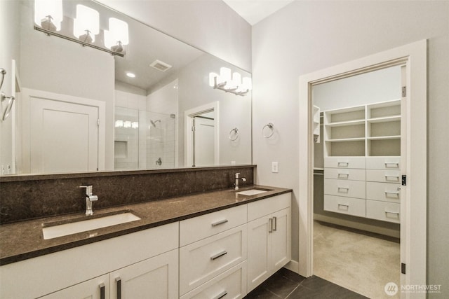 full bathroom featuring visible vents, a sink, a stall shower, and double vanity