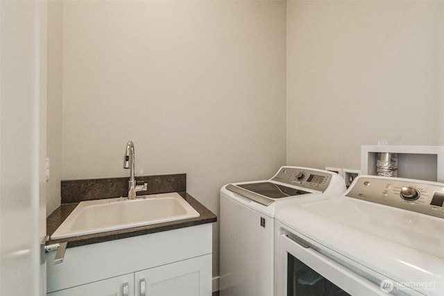 laundry area featuring a sink, cabinet space, and washer and clothes dryer