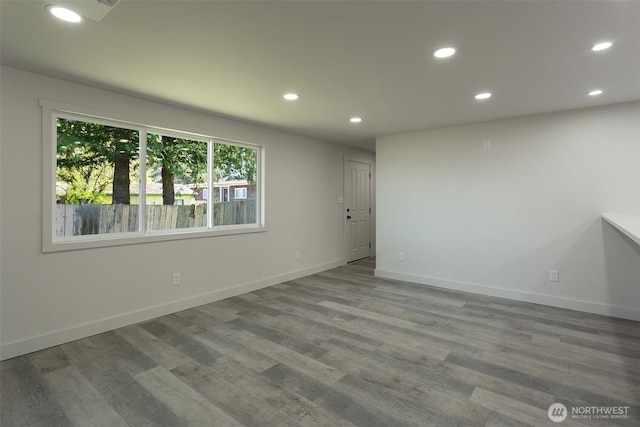 unfurnished room featuring baseboards, recessed lighting, and wood finished floors