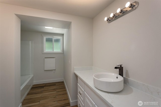 full bathroom with vanity, baseboards, and wood finished floors