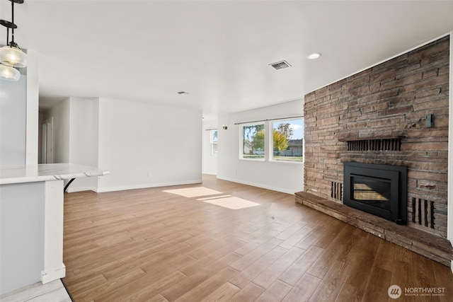 801 E Manitoba Ave, Ellensburg, WA 98926 - unfurnished living room featuring a fireplace, baseboards, visible vents, and light wood-style flooring