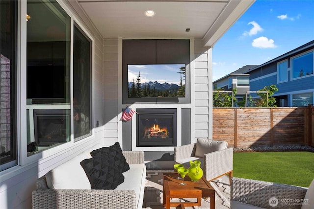 view of patio / terrace featuring fence and an outdoor living space with a fireplace