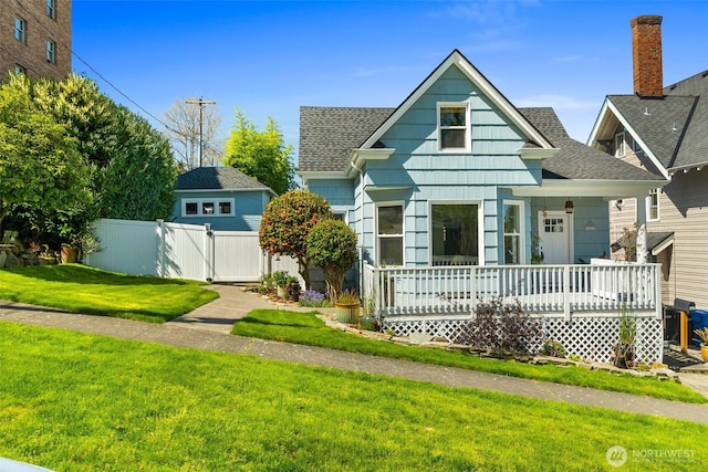 707 N 10th St, Tacoma, WA 98403 - bungalow-style house featuring roof with shingles, a porch, a front yard, and fence