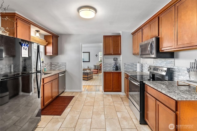 707 N 10th St, Tacoma, WA 98403 - kitchen featuring brown cabinets, decorative backsplash, and stainless steel appliances