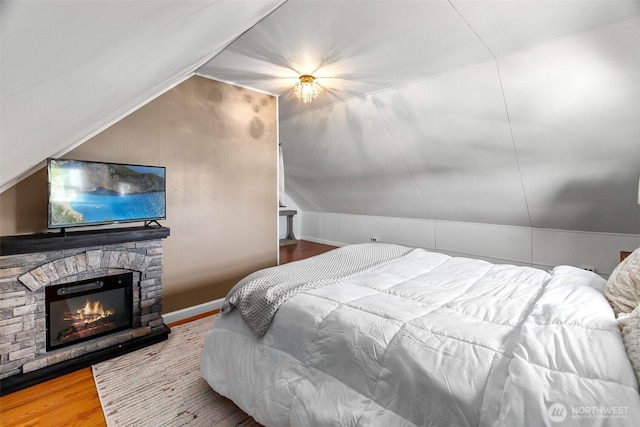 707 N 10th St, Tacoma, WA 98403 - bedroom featuring a stone fireplace, vaulted ceiling, and wood finished floors