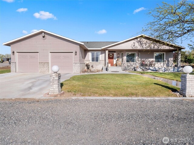 single story home with concrete driveway, a front lawn, brick siding, and a garage