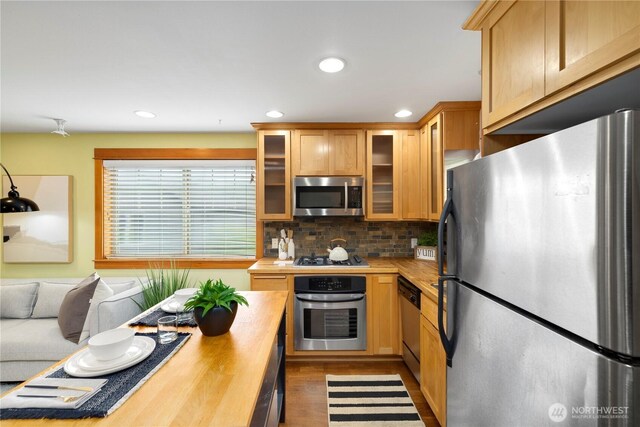 kitchen featuring backsplash, stainless steel appliances, recessed lighting, and butcher block counters