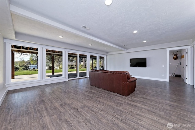 living area featuring dark wood-type flooring, a textured ceiling, baseboards, and recessed lighting