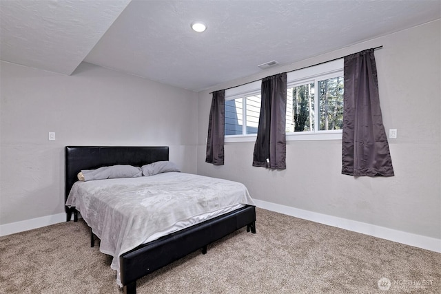 bedroom with baseboards, visible vents, and carpet flooring
