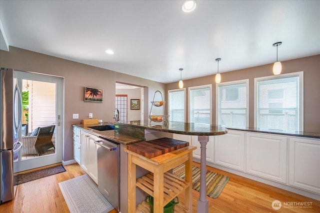 5015 SW Prince St, Seattle, WA 98116 - kitchen featuring a sink, appliances with stainless steel finishes, a peninsula, healthy amount of natural light, and recessed lighting