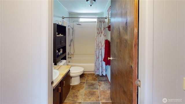 bathroom with stone finish floor, shower / tub combo with curtain, toilet, and vanity