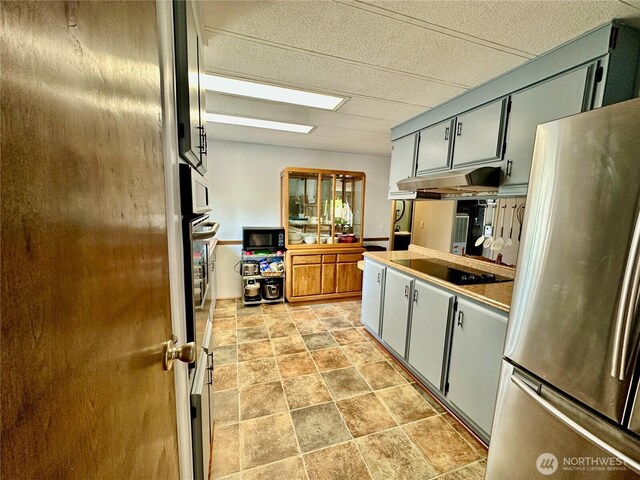 4317 Hamilton Dr, Oak Harbor, WA 98277 - kitchen featuring black appliances, under cabinet range hood, stone finish flooring, and gray cabinets