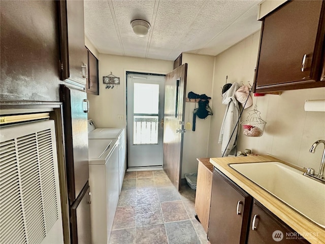 4317 Hamilton Dr, Oak Harbor, WA 98277 - laundry room featuring independent washer and dryer, cabinet space, light stone finish floors, a heating unit, and a textured ceiling