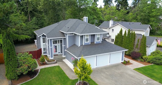 view of front of house featuring a chimney, a front yard, roof with shingles, a garage, and fence