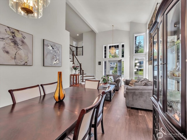 dining room with stairway, high vaulted ceiling, and dark wood-type flooring