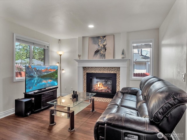 living room with a glass covered fireplace, baseboards, recessed lighting, and wood finished floors