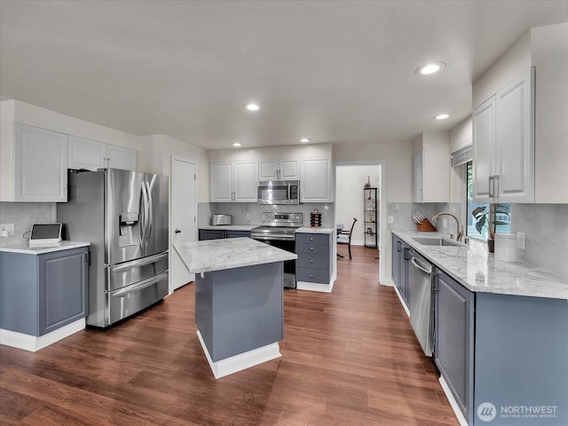 kitchen with a kitchen island, stainless steel appliances, dark wood-style floors, and a sink