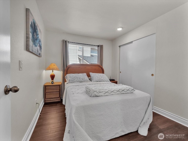bedroom featuring baseboards, a closet, and dark wood-style flooring