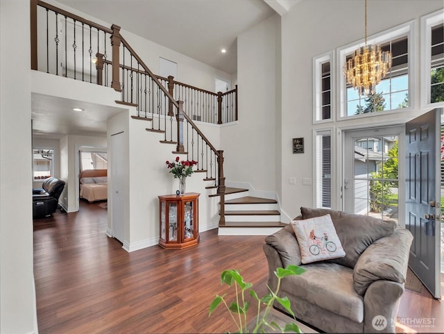 interior space featuring an inviting chandelier, a high ceiling, stairway, and wood finished floors