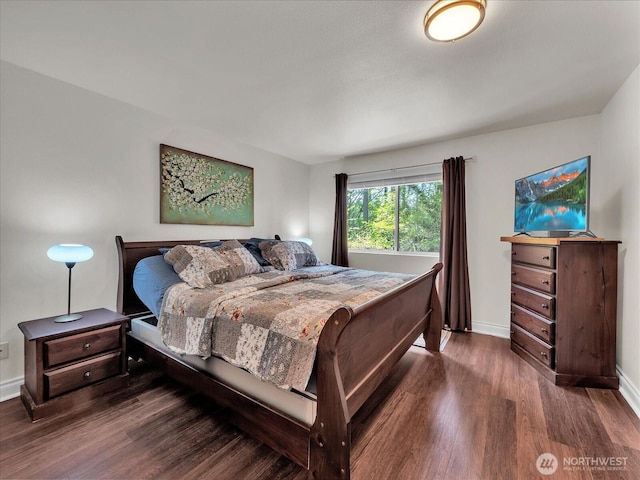 bedroom with baseboards and wood finished floors
