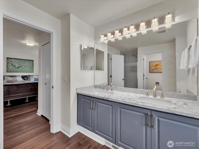 full bath with wood finished floors, baseboards, a sink, and ensuite bath