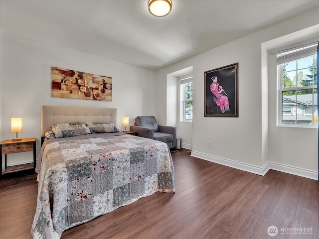 bedroom featuring baseboards, dark wood-style floors, and multiple windows