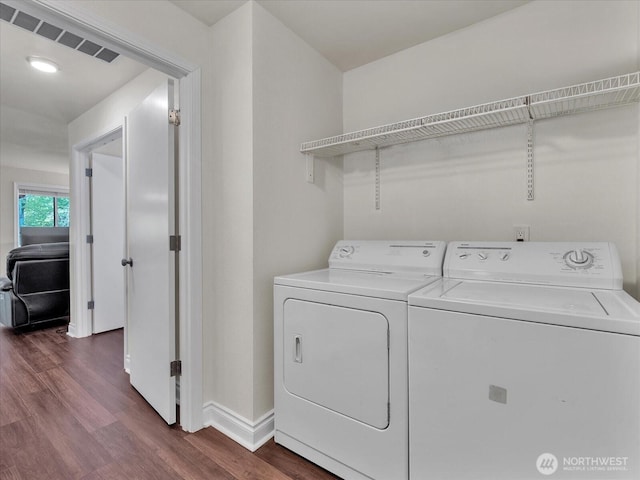 washroom with independent washer and dryer, laundry area, baseboards, visible vents, and dark wood-style floors