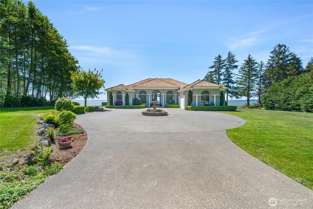 41 Gray Gables Ln, Hoquiam, WA 98550 - mediterranean / spanish home featuring curved driveway, a front lawn, and stucco siding
