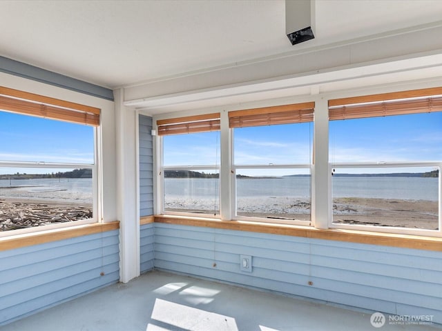 unfurnished sunroom with a water view